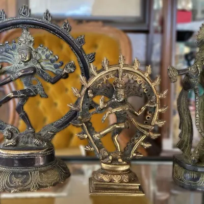 Sale Photo Thumbnail #2: Trio of vintage bronze Hindu deities, including two Shiva Nataraja dancing figures and one Krishna playing the flute, featuring intricate cast details and aged patina.