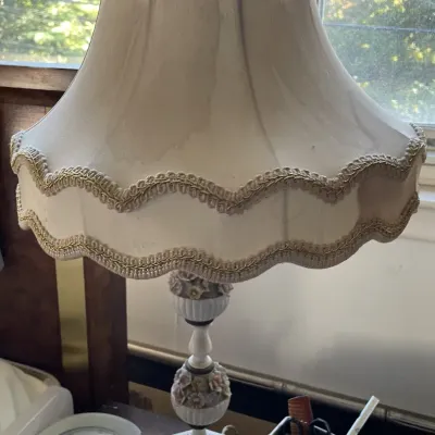 Sale Photo Thumbnail #112: Vintage ceramic table lamp featuring applied floral accents and an ornate fabric shade with braided trim.