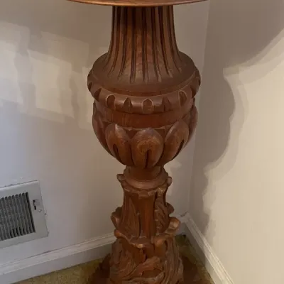 Sale Photo Thumbnail #157: Ornately carved wooden plant stand or pedestal featuring intricate acanthus leaf and urn-shaped detailing with a round top.
