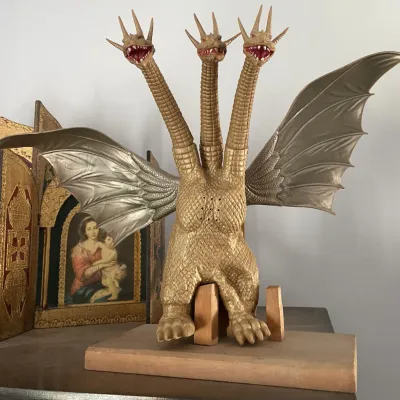Sale Photo Thumbnail #111: Vintage King Ghidorah vinyl action figure mounted on a wooden base, featuring three heads and detailed metallic wings.