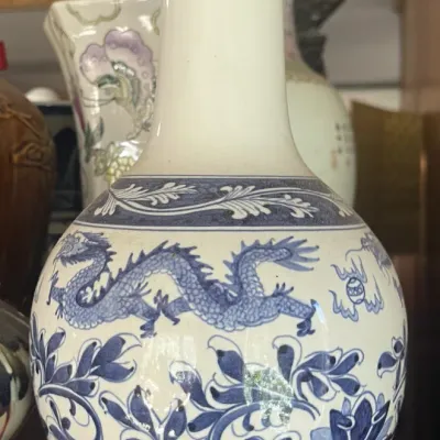 Sale Photo Thumbnail #166: Vintage Chinese blue and white porcelain bottle vase featuring hand-painted dragon and floral motifs with a Greek key border along the rim.