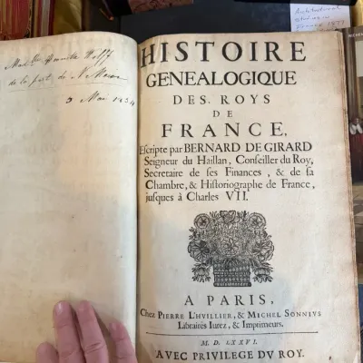 Sale Photo Thumbnail #71: Title page of an antique French history book titled "Histoire Genealogique des Roys de France" by Bernard de Girard, dated 1576, featuring handwritten inscriptions on the flyleaf.
