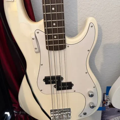 Sale Photo Thumbnail #93: White Precision-style 4-string electric bass guitar with a white pickguard and rosewood fretboard.