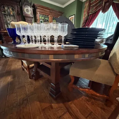Sale Photo Thumbnail #6: Round wood dining table with a slate tile mosaic apron, displayed with crystal stemware