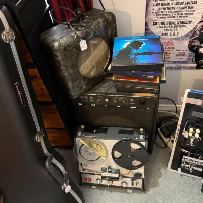 Sale Photo Thumbnail #113: Collection of vintage music gear, including a Sony reel-to-reel tape player, guitar amplifiers, vinyl box sets, and a hardshell guitar case.