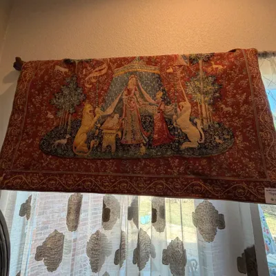 Sale Photo Thumbnail #188: Large woven tapestry wall hanging depicting 'The Lady and the Unicorn' scene against a rich red background, displayed on a rod.