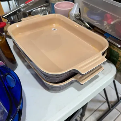 Sale Photo Thumbnail #264: Pair of stacked Le Creuset rectangular stoneware baking dishes in grey with cream interior, shown in excellent condition.