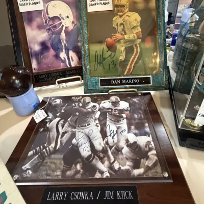 Sale Photo Thumbnail #45: Collection of signed Miami Dolphins memorabilia plaques, including autographed photos of Dan Marino, Larry Csonka, and Jim Kiick.