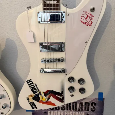 Sale Photo Thumbnail #94: White electric Johnny Winter tribute guitar with graphic decals, chrome hardware, and white pickguard featuring the red Firebird logo.