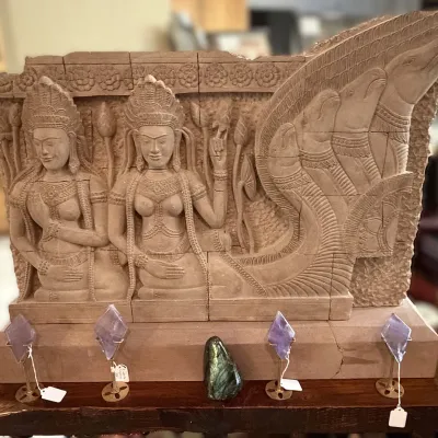 Sale Photo Thumbnail #184: Large carved stone relief plaque depicting Khmer figures and a multi-headed Naga snake, displayed on a console table above brass candelabras.
