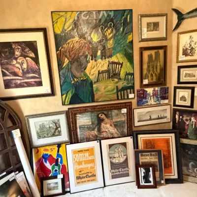 Sale Photo Thumbnail #244: Eclectic gallery wall featuring various framed art prints, oil paintings, vintage White Castle advertisements, and decorative architectural pieces.