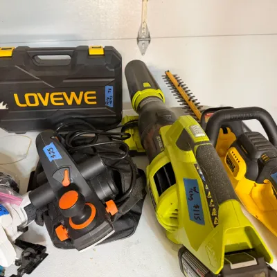 Sale Photo Thumbnail #349: Collection of power tools including a Ryobi leaf blower, DeWalt chainsaw, Makita circular saw, electric hand planer, and a Lovewe hard tool case.