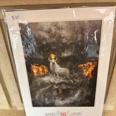 Sale Photo Thumbnail #159: Fantasy art print by Yoann Lossel featuring a white stag amidst a dark, firelit forest scene, sealed in protective plastic sleeves.