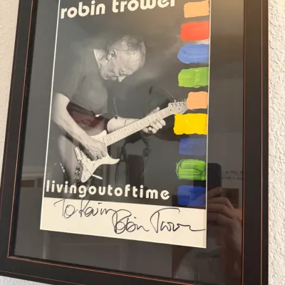 Sale Photo Thumbnail #110: Framed Robin Trower 'Living Out of Time' concert poster, personalized and autographed by the artist in black.