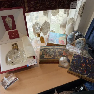 Sale Photo Thumbnail #133: Collection of collectibles including a boxed Rémy Martin Louis XIII cognac crystal decanter, decorative trinket boxes with medieval tapestry designs, and crystal geodes.