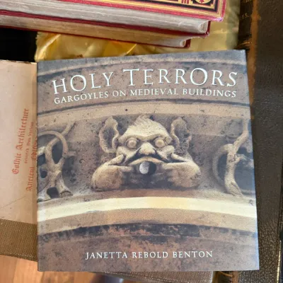 Sale Photo Thumbnail #68: Paperback copy of 'Holy Terrors: Gargoyles on Medieval Buildings' by Janetta Rebold Benton, displayed alongside vintage decorative books.