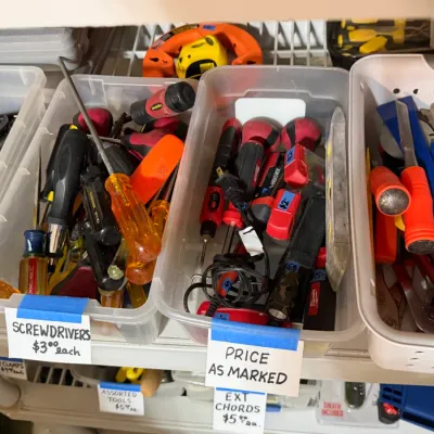 Sale Photo Thumbnail #316: Plastic bins containing a variety of hand tools, including screwdrivers, wrenches, and pry bars, are neatly arranged on storage shelving.