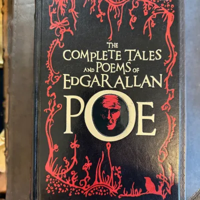 Sale Photo Thumbnail #72: Hardcover edition of "The Complete Tales and Poems of Edgar Allan Poe" featuring a decorative black and red cover design with a stylized portrait.