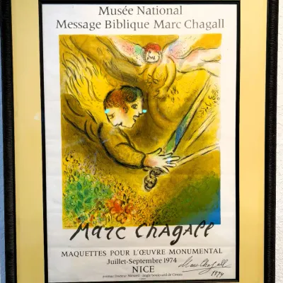 Sale Photo Thumbnail #169: Framed 1974 Marc Chagall exhibition poster from the Musée National Message Biblique Marc Chagall in Nice, featuring vibrant artwork in a textured dark frame with a wide mat.