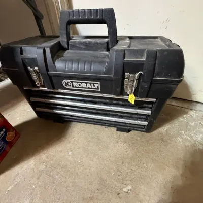 Sale Photo Thumbnail #299: Black Kobalt portable plastic toolbox with metal drawer slides and latches, showing light dust and wear.