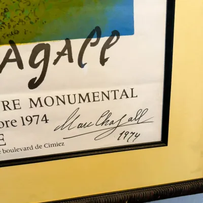 Sale Photo Thumbnail #170: Close-up detail of a framed Marc Chagall exhibition poster from 1974, featuring a hand-written signature and date in the bottom right corner.