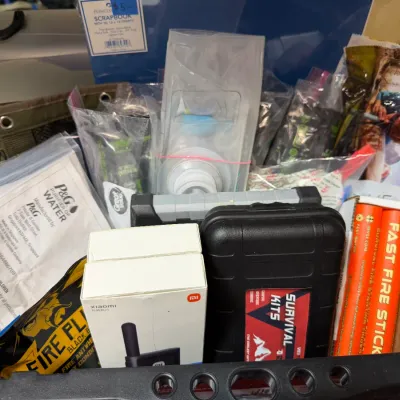 Sale Photo Thumbnail #365: Collection of emergency preparedness gear, including Xiaomi electronics, survival kits, P&G water purifier packets, and Fast Fire Sticks.