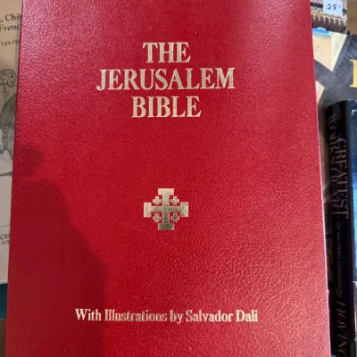 Sale Photo Thumbnail #76: 1970 Illustrated edition of 'The Jerusalem Bible' featuring artwork by Salvador Dali, bound in red leatherette with gold gilt lettering.