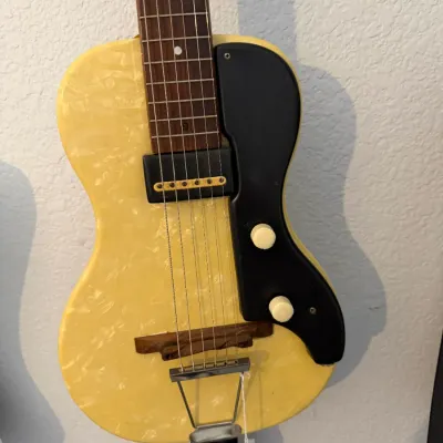 Sale Photo Thumbnail #95: Vintage Magnatone Mother-of-Pearloid electric guitar featuring a cream pearloid body finish, single-coil pickup, black pickguard, and wooden floating bridge.