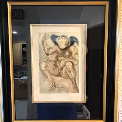 Sale Photo Thumbnail #175: Framed Salvador Dalí print, housed in a thick black frame with gold accents.