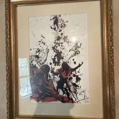 Sale Photo Thumbnail #217: Framed Salvador Dalí surrealist print, dated 1964, mounted behind glass in an ornate gold-finished molding frame.