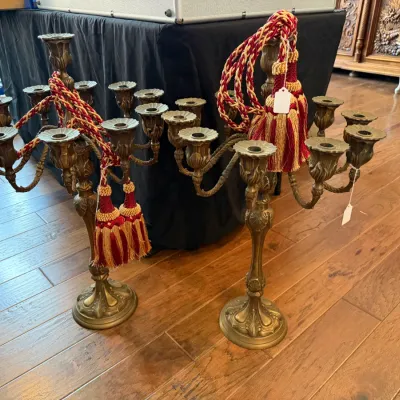 Sale Photo Thumbnail #163: Pair of ornate vintage brass multi-arm candelabras featuring acanthus leaf details and red-and-gold decorative tassels.