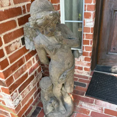 Sale Photo Thumbnail #281: Weathered cast concrete or stone garden statue of a cherub, featuring detailed wings, drapery, and a natural stone-like patina (Pair)