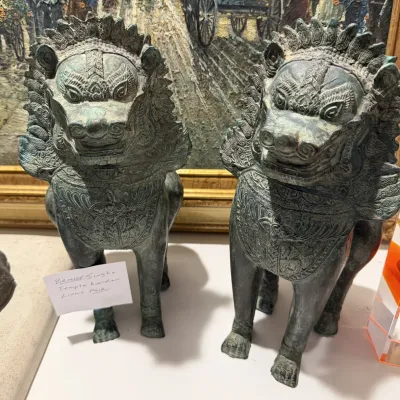 Sale Photo Thumbnail #200: Pair of Southeast Asian bronze Singha temple guardian lion statues featuring detailed relief carving and aged verdigris patina.