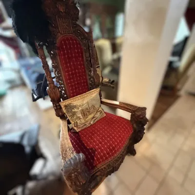 Sale Photo Thumbnail #25: Ornately carved Gothic Revival throne chair featuring dark wood finish, red tufted upholstery, and detailed cresting.